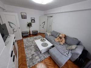 un osito de peluche sentado en un sofá en una sala de estar en Apartament 2 camere en Zalău