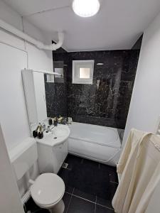 a bathroom with a sink and a toilet and a tub at Apartament 2 camere in Zalău