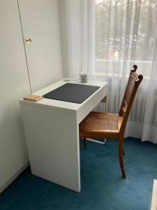 a white desk with a chair next to a window at Ruhiges Zimmer in guter Lage in Aalen/Unterkochen in Aalen