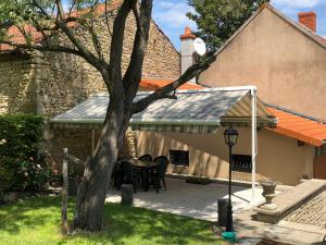 a patio with a table and chairs in front of a house at Gîte de la Croix Mandet in Vensat