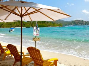 two chairs and an umbrella on a beach at A Son de Mar - Playa Las Gatas acceso por mar in Zihuatanejo