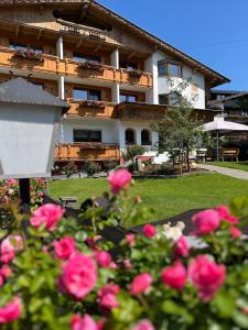 a building with pink roses in front of it at Apartment Sonnwend in Reith im Alpbachtal