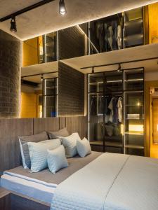 una camera da letto con un grande letto con cuscini bianchi di PAUZA apartman a Novi Sad