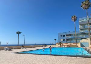 a person standing in a swimming pool next to a building at Casa Elena in Candelaria