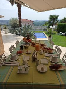 a table with plates of food on it with a pool at villa josepha in Cournon-dʼAuvergne