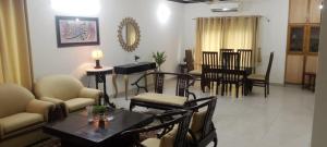 a living room with a table and chairs at Impeccable 3-Bed Apartment in Lahore in Lahore