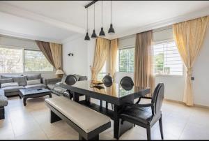 a living room with a table and a couch at Luxueux et moderne duplex in Hay Riad in Rabat