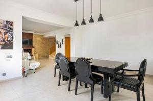 a dining room with a black table and black chairs at Luxueux et moderne duplex in Hay Riad in Rabat
