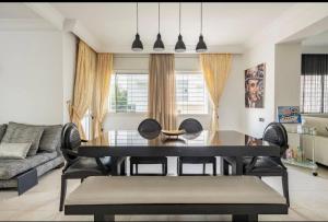 a dining room table and chairs in a living room at Luxueux et moderne duplex in Hay Riad in Rabat