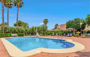 a swimming pool in a yard with palm trees at Lovely Home In Elche With Kitchenette in Elche