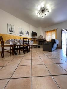 ein Wohnzimmer mit einem Tisch, Stühlen und einem Sofa in der Unterkunft Villa Marina in Torvaianica