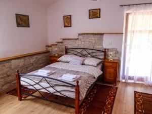 1 dormitorio con cama y pared de piedra en Casa istriana nona Pina, en Kaštelir