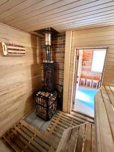 a wood stove in a cabin with a pool at Edelweiss House in Svityazʼ