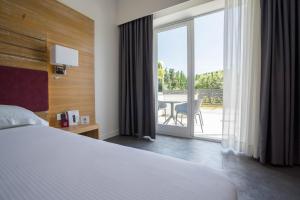 カタンツァーロ・リドにあるPM Hotelのベッド付きのホテルルームで、パティオの景色を望めます。