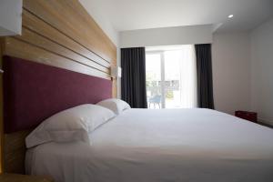 a bedroom with a large white bed with a window at PM Hotel in Catanzaro Lido