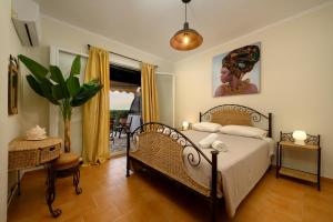 a bedroom with a bed and a potted plant at Seaduced Beachfront Villa by CorfuEscapes in Glyfada +22 photos