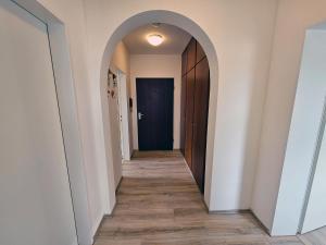 um corredor com um arco e uma porta azul em Ferienwohnung Bergblick - a66742 em Bad Sachsa