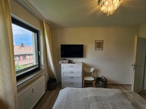 um quarto com uma cama, uma televisão e uma janela em Ferienwohnung Bergblick - a66742 em Bad Sachsa