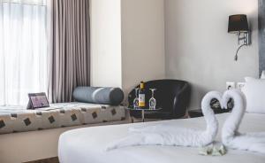 ein Hotelzimmer mit 2 Schwänen auf einem Bett in der Unterkunft Benjamin Business Hotel in Herzlia