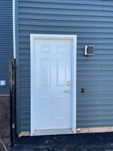 a white door on the side of a house at Beautiful 1 bedroom apartment - private entrance in Moncton