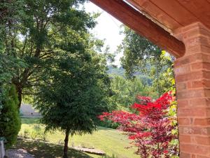 una vista desde el porche de una casa con árboles y flores en Il Nascondiglio - The Hideaway, en Amandola