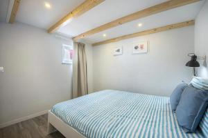 a bedroom with a bed with blue and white stripes at Casa da Villa in Vila do Bispo