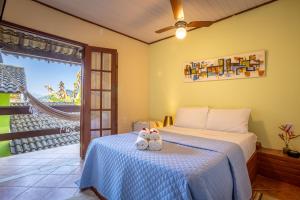 een slaapkamer met een bed met twee knuffels erop bij Pousada Cruzoé in Praia de Araçatiba