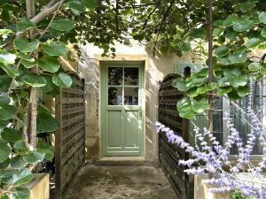 eine grüne Tür auf einem Haus mit Pflanzen in der Unterkunft Clos de la Noria in Pont-Saint-Esprit