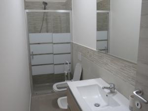 uma casa de banho com um WC, um lavatório e um espelho. em Il Tarassaco-exclusive pool em Santa Maria a Monte