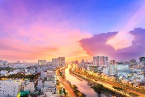 a city skyline at sunset with a river and buildings at REM Rivergate Garden Pool Signature - Free 4G sim for 3 Nights Booking in Ho Chi Minh City