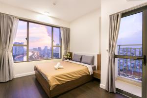 a bedroom with a bed and large windows at REM Rivergate Garden Pool Signature - Free 4G sim for 3 Nights Booking in Ho Chi Minh City