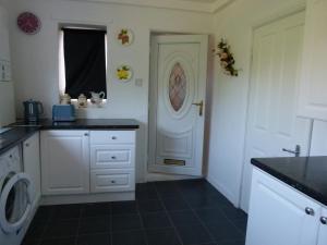 eine Küche mit einer Waschmaschine und einer weißen Tür in der Unterkunft Holly in Middlesbrough