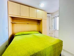 um quarto com uma cama verde num quarto em Casa Silvia - Immobilevante em Ponza