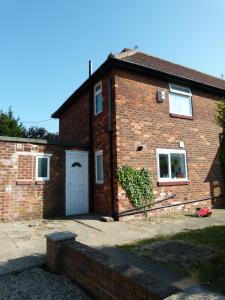 a brick house with a white door and a yard at Holly in Middlesbrough