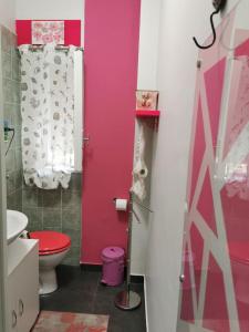 bagno con servizi igienici e parete rosa di Mq 36 a Marsala