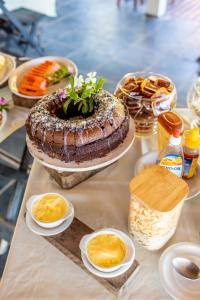 une table recouverte d'un grand gâteau et d'autres aliments dans l'établissement Pousada Cruzoé, à Praia de Araçatiba