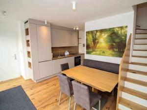 Il comprend une cuisine et une salle à manger avec une table et des chaises en bois. dans l'établissement Luxury 2-floor Rooftop Apartment with terrace in the city center, à Vienne