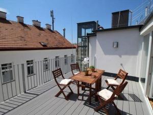 d'une table et de chaises en bois sur un balcon. dans l'établissement Luxury 2-floor Rooftop Apartment with terrace in the city center, à Vienne