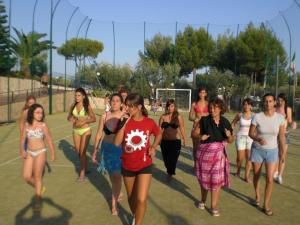 un grupo de personas caminando en una pista de tenis en Villaggio Turistico Defensola, en Vieste