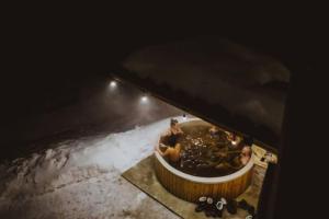 a hot tub in the snow with people in it at Aframehouse in Şurdeşti