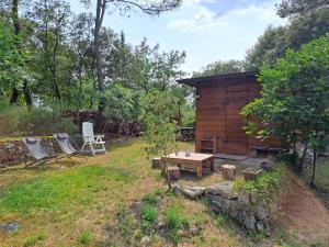 a wooden cabin with a table and chairs in a yard at Cabane Eco Lodge in Tourrettes-sur-Loup