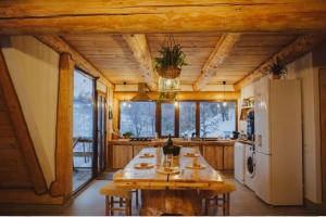 a large kitchen with a table and a refrigerator at Aframehouse in Şurdeşti