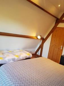 - une chambre avec un lit et un mur en bois dans l'établissement Maison du domaine de la petitière, à Bonneville-la-Louvet