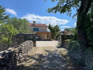 een huis met een stenen hek en een stenen muur bij Family-sized renovated Istrian house w/lavand field - 20min from Rovinj. in Žminj