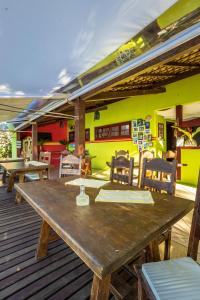 uma mesa de madeira e cadeiras num deque em Pousada Cruzoé em Praia de Araçatiba