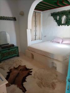ein Schlafzimmer mit einem Bett und einem Teppich in einem Zimmer in der Unterkunft Typique appartement in Houmt Souk