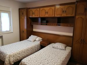 オビエドにあるApartamento Dominicosの小さな部屋のベッド2台 木製キャビネット付