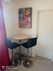 a table and two blue chairs in a room at CHARMANT & PRATIQUE, 2 Pièces/4 Pers à 15 min de Paris et Versailles in Ville-dʼAvray