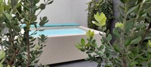 una piscina seduta sul lato di un edificio con piante di Villa Totò Resort a Cefalù