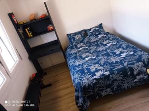 - une chambre dotée d'un lit avec une couverture bleue et blanche dans l'établissement CHARMANT & PRATIQUE, 2 Pièces/4 Pers à 15 min de Paris et Versailles, à Ville-dʼAvray